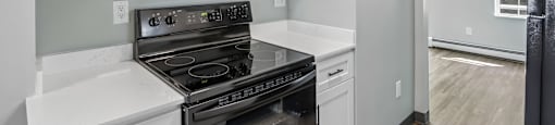 A kitchen with a stove, microwave, and cabinets.