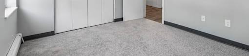 A room with a carpeted floor and a white door.