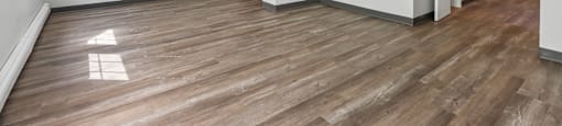 A room with wooden flooring and white walls.