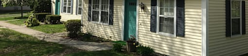 A house with a green door and black shutters.