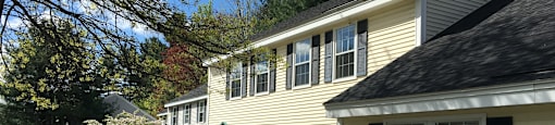 A house with a green door and white siding is shown.