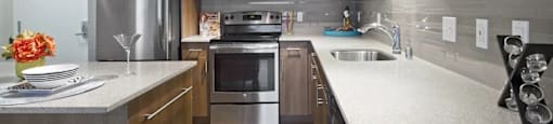 A modern kitchen with a stainless steel refrigerator, microwave, oven, and sink at Astro, Seattle, WA, 98109