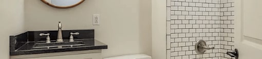 a bathroom with white walls and a wooden floor