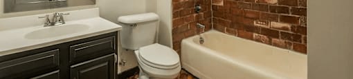a bathroom with a white toilet next to a bathtub