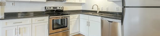 a kitchen with white cabinets and stainless steel appliances