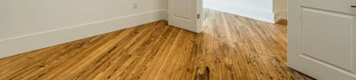 a bedroom with white walls and a wooden floor