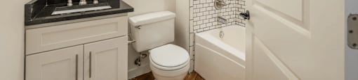 a bathroom with a white toilet next to a white bathtub