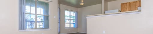 an empty living room with a ceiling fan and a window