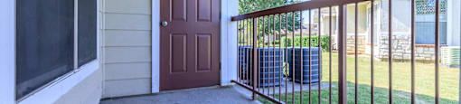 the entrance to a house with a porch and a brown door