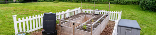 a garden with a raised garden bed and a fence at Eagles Landing Apartments, Everett, 98204