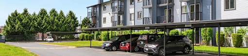a parking lot with cars in front of an apartment building at Eagles Landing Apartments, Everett, WA 98204  