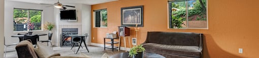 a living room with couches and a table and a ceiling fan at Eagles Landing Apartments, Everett, WA