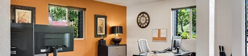 a dining room with a glass table and chairs and a desk with a computer at Eagles Landing Apartments, Everett, WA