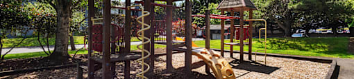 a playground with a swing set and other play equipment at Eagles Landing Apartments, Everett, 98204