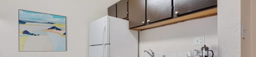 a small kitchen with a white dishwasher and a refrigerator at Eagles Landing Apartments, Everett  
