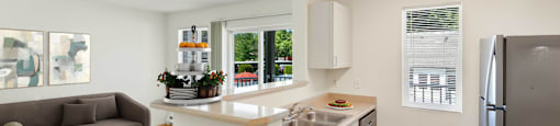 a living room with a couch and a kitchen with a sink at Sage Apartments, Everett, Washington