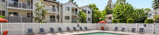 our apartments have a resort style pool with chairs at Sage Apartments, Everett