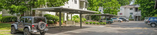 a parking lot with a jeep parked in front of a house at Sage Apartments, Everett, Washington