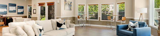 a living room with a white couch and a blue chair at Sage Apartments, Everett, 98204