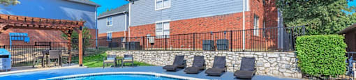 a large swimming pool with chairs in front of a house at Villas of Sorrento Apartments, Dallas
