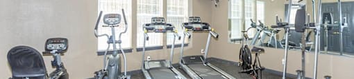 a gym with various exercise equipment on the floor at Villas of Sorrento Apartments, Dallas