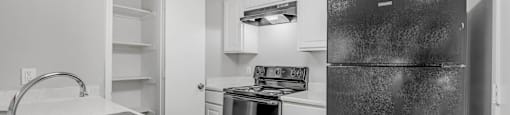 a kitchen with stainless steel appliances and white cabinets at Villas of Sorrento Apartments, Texas, 75241