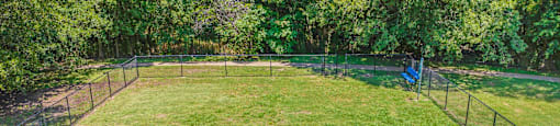 a fenced in batting cage in the middle of a grass field at Villas of Sorrento Apartments, Dallas, TX