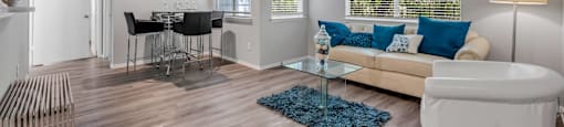 a living room with a couch and a ceiling fan at Villas of Sorrento Apartments, Dallas, TX
