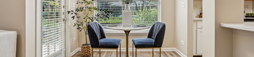 A dining room with a table and chairs.
