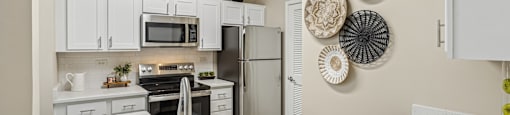 A modern kitchen with a stainless steel sink and refrigerator.