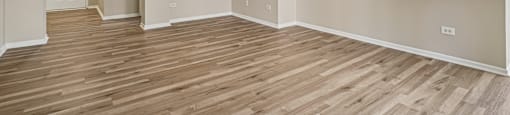 A room with a ceiling fan and wooden flooring.