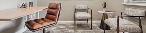 A room with a brown chair and two white chairs.