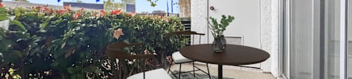 a small patio with a table and chairs and a window