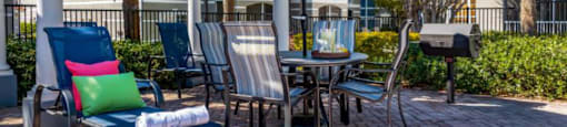 patio with a table and chairs under an umbrella at Mainstreet Apartments, Clearwater, FL