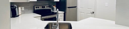 white kitchen with a sink and a microwave at Mainstreet Apartments, Florida, 33756