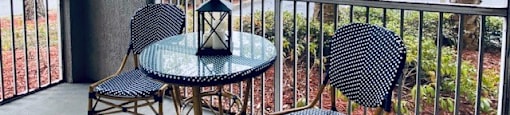 balcony with a table and chairs and a large window at Mainstreet Apartments, Clearwater, Florida