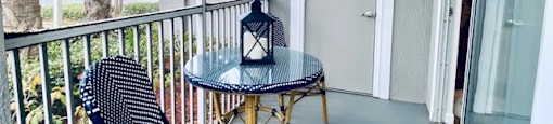 balcony with two chairs and a table and a door at Mainstreet Apartments, Clearwater