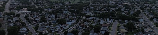A sunset over a residential area with houses and streets.