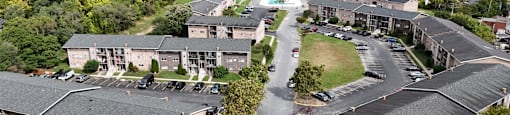 A large apartment complex with a parking lot in front.