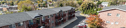 A parking lot in front of a red brick apartment complex.