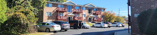 A street view of a residential area with cars parked on the side of the road.