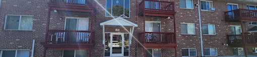 A red brick building with a white door and windows.