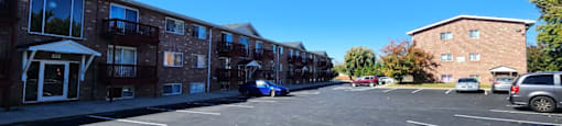 A parking lot with a car parked in front of a brick building.