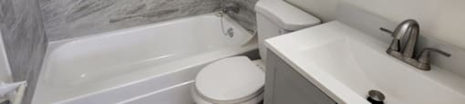 A bathroom with a marble wall and a white sink.