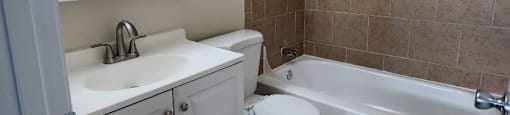 A bathroom with a sink, toilet, and bathtub.