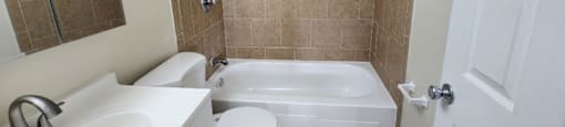 A bathroom with a white toilet, sink, and bathtub.