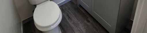 A white toilet sits next to a sink in a small bathroom.