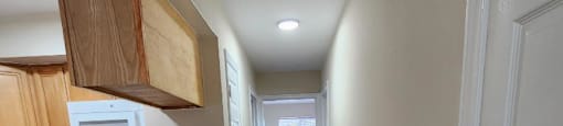 A long hallway with a kitchen area on the left.