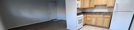 A kitchen with white appliances and wooden cabinets.