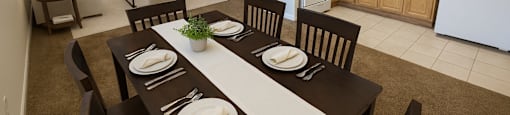 A dining room with a table set for two with a view of the kitchen.